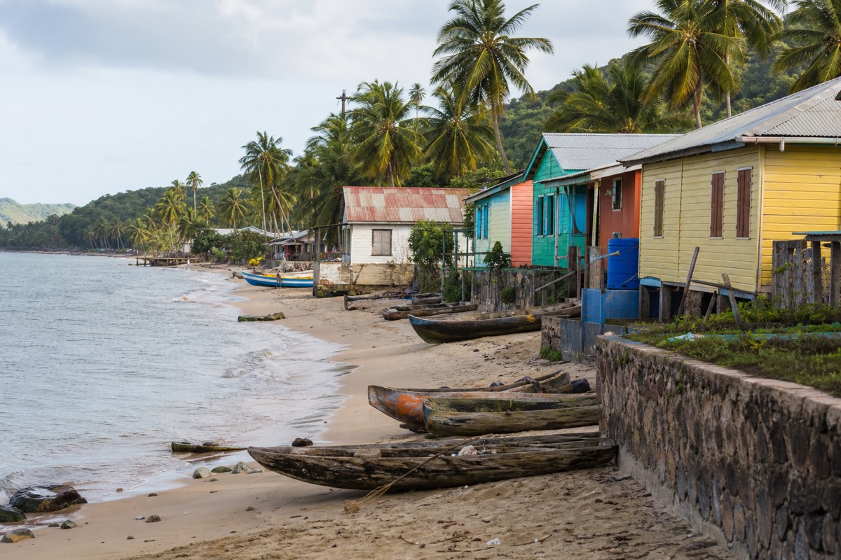 Timber houses and small boats along the shore of a Garifuna village on Roatan's east end